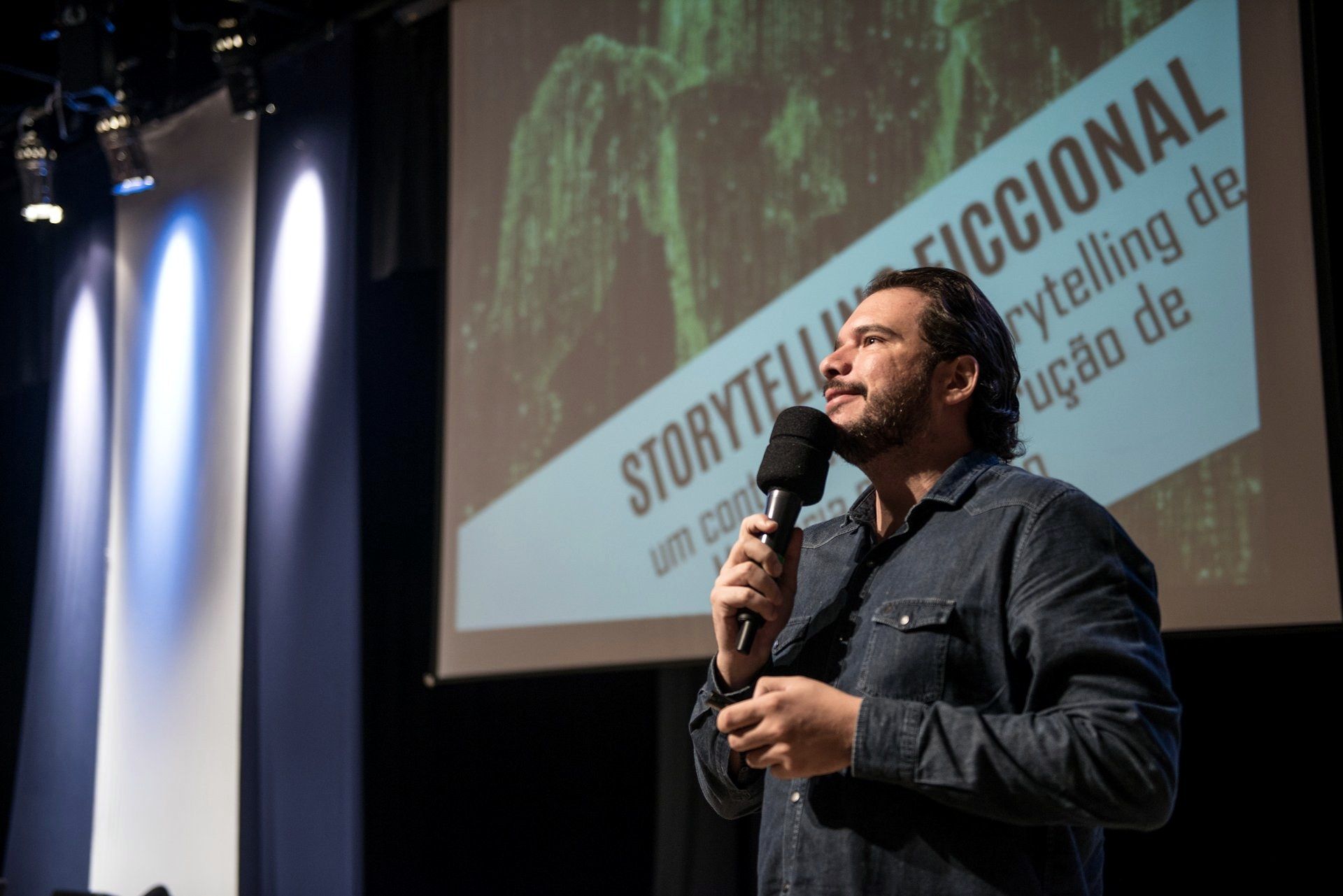 Fernando Palacios speaking on stage with a slide titled fictional storytelling behind him