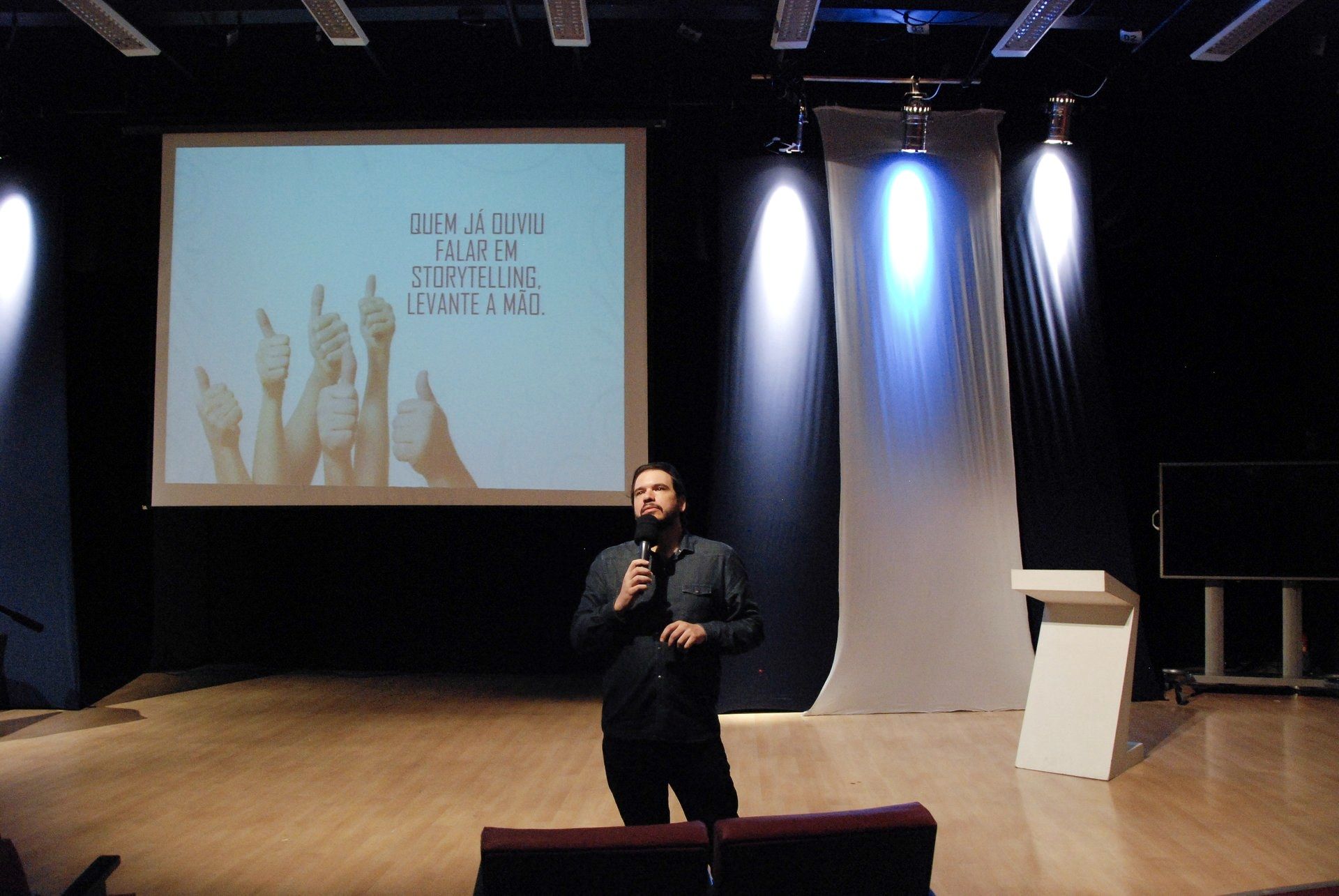 Fernando Palacios on stage opening a storytelling talk, the screen behind him asking who has heard of storytelling