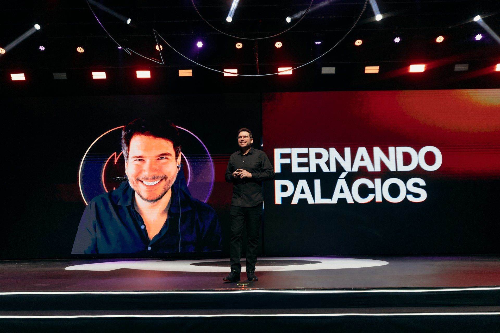 Fernando Palacios on stage, his name across the LED wall